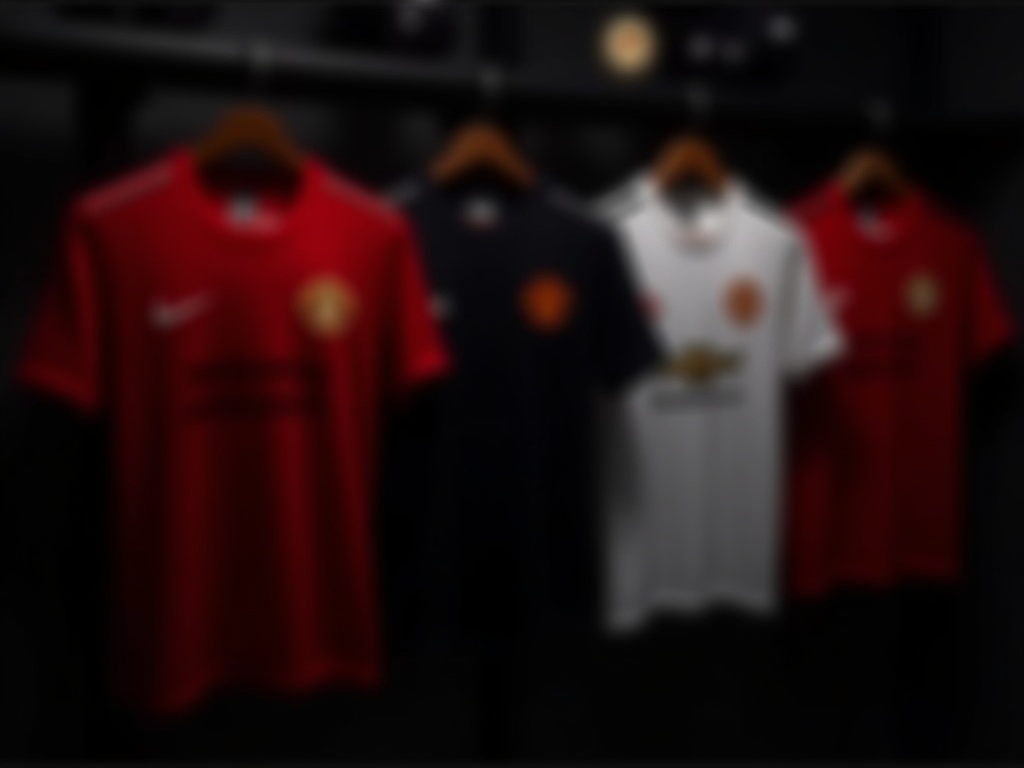 Plusieurs maillots de foot Manchester United alignés en boutique concept